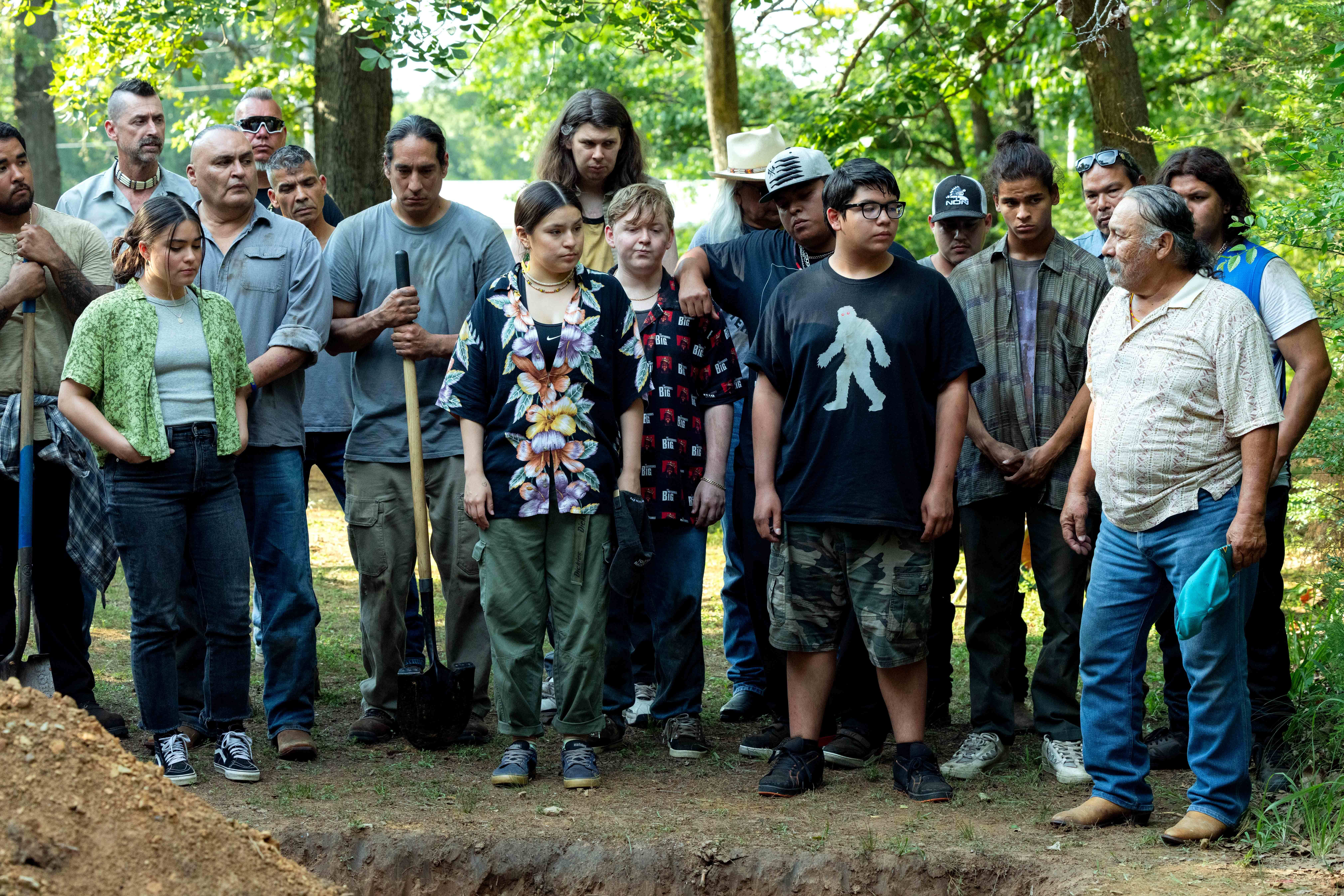 The cast of Rez Dogs stands around a grave they just built in the finale.