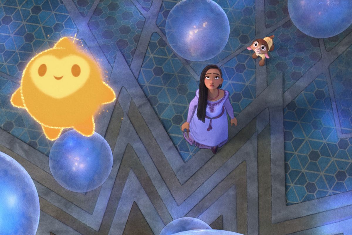 Star, a little yellow star-shaped blob with a childlike face, hovers among glowing blue-purple orbs above human protagonist Asha (Ariana DeBose) and her talking goat Valentino (Alan Tudyk) in Disney’s animated feature Wish